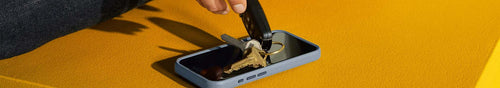 Keys dropping on an OtterBox Glass Screen Protector on iPhone with a yellow background