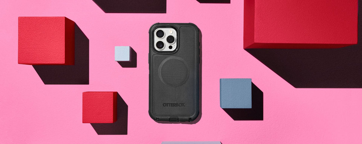 Protective black OtterBox Defender Series for iPhone 16 Pro and Pro Max on a pink background