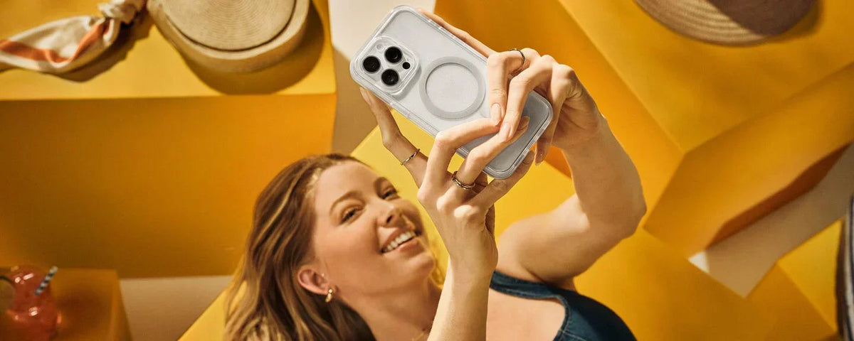 Woman taking a selfie on a white iPhone 16 Pro in a clear, MagSafe OtterBox Symmetry Series iPhone case