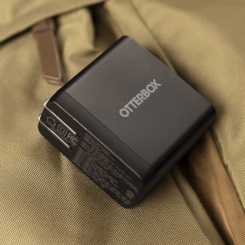 Wall charger sitting on green canvas back pack