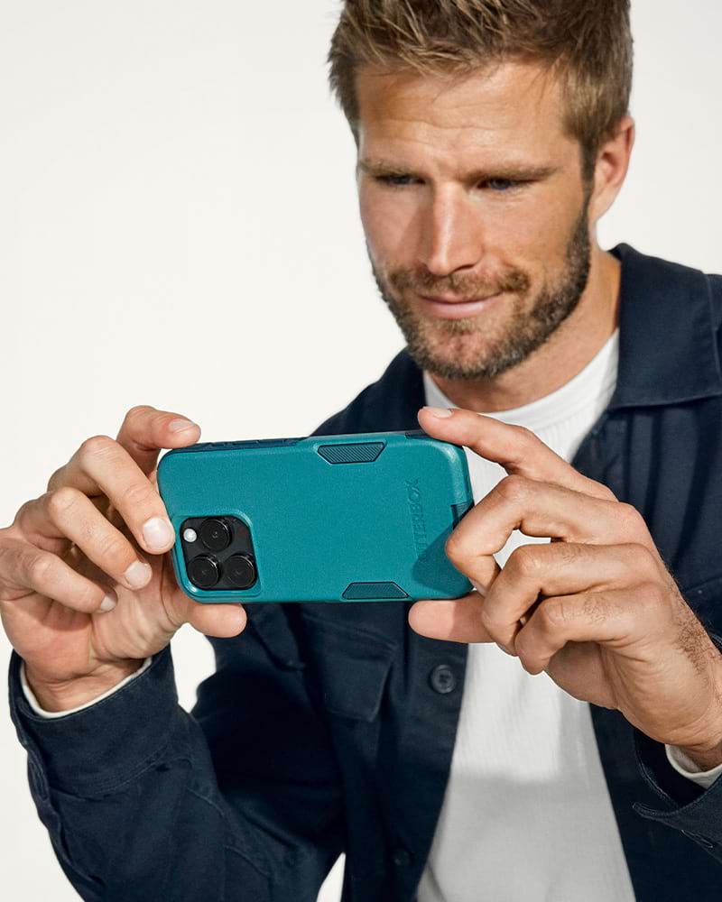 man holding iphone 16 in a green otterbox commuter series phone case