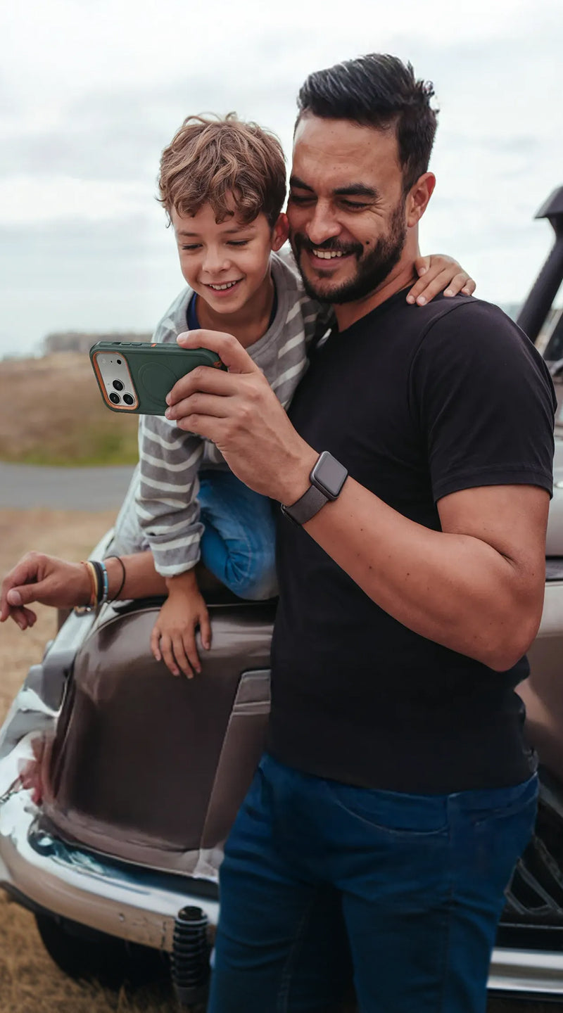 Man and child taking a selfie outdoors near a vehicle