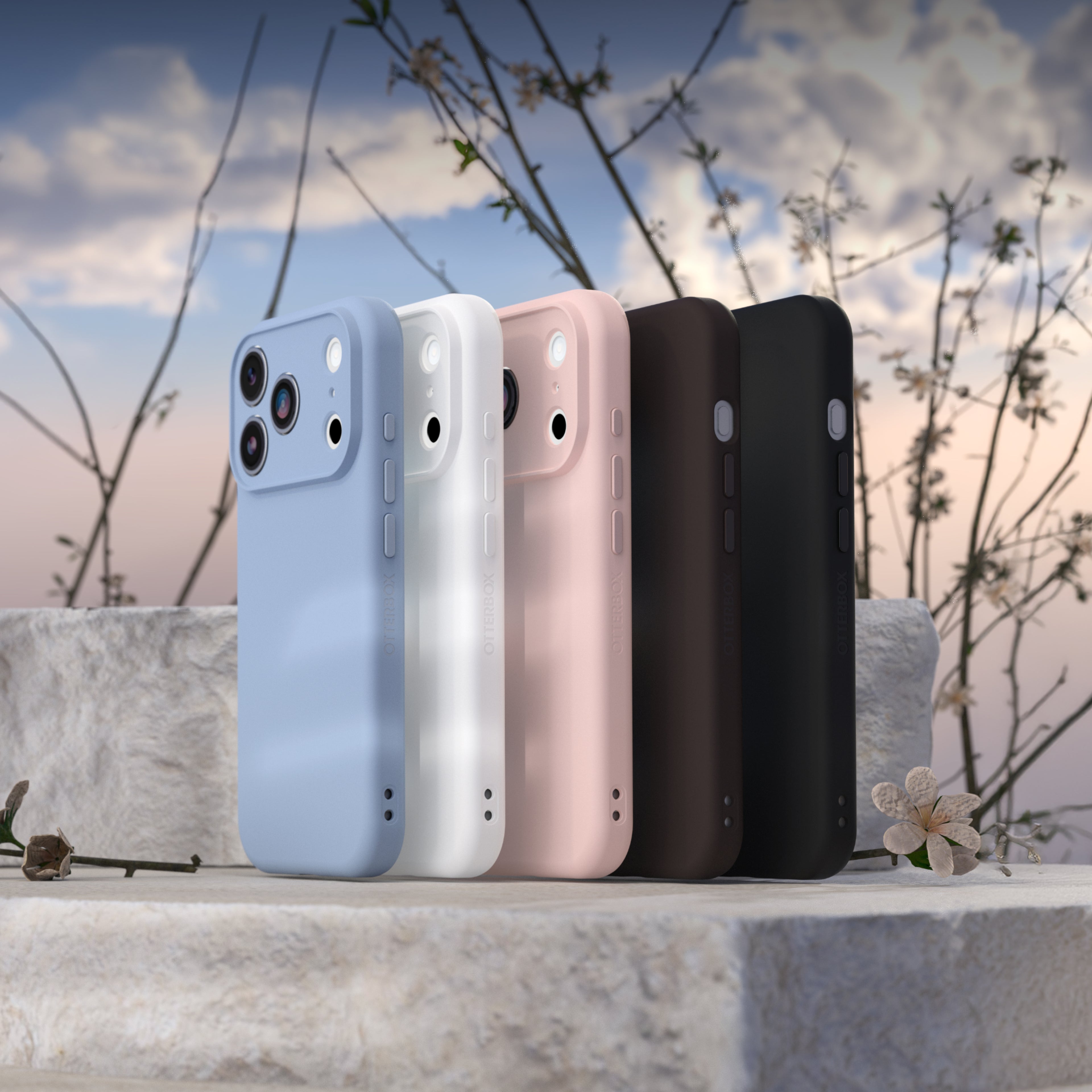 Four iPhones in different colors on a stone surface with a natural background