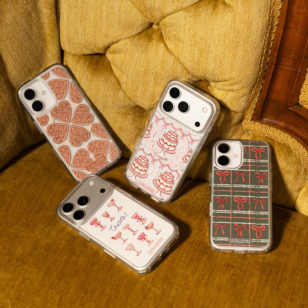 Four phone cases with different designs on a wooden surface.