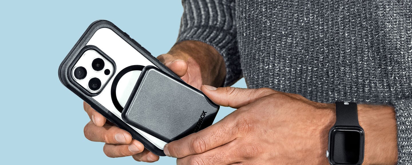 Person holding a phone with a case against a blue background