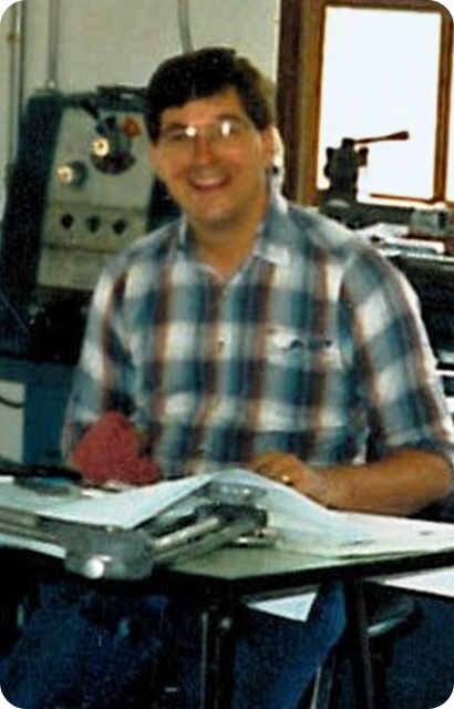 Person sitting at a desk with equipment in the background