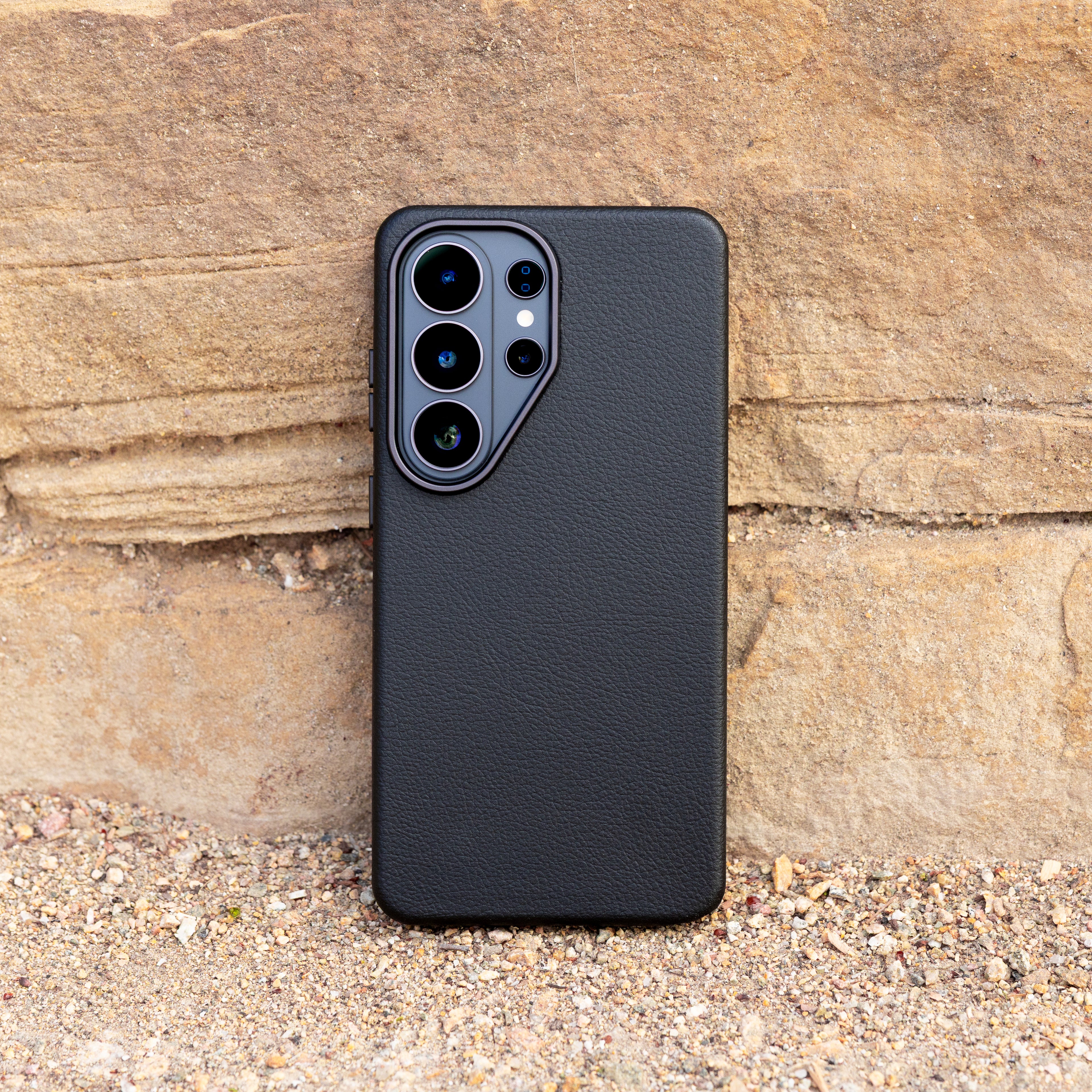 Black faux leather phone case on a stone surface