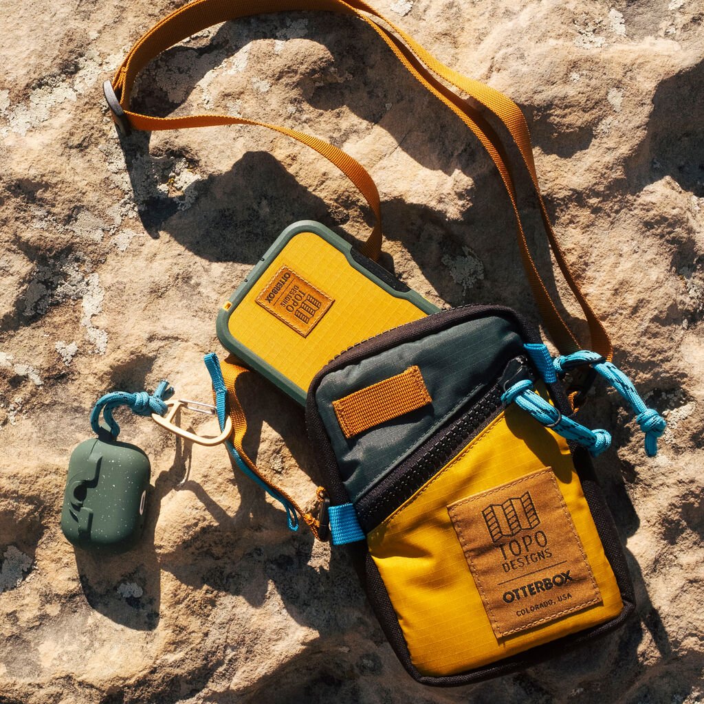 Yellow and green bag with a keychain on a rocky surface