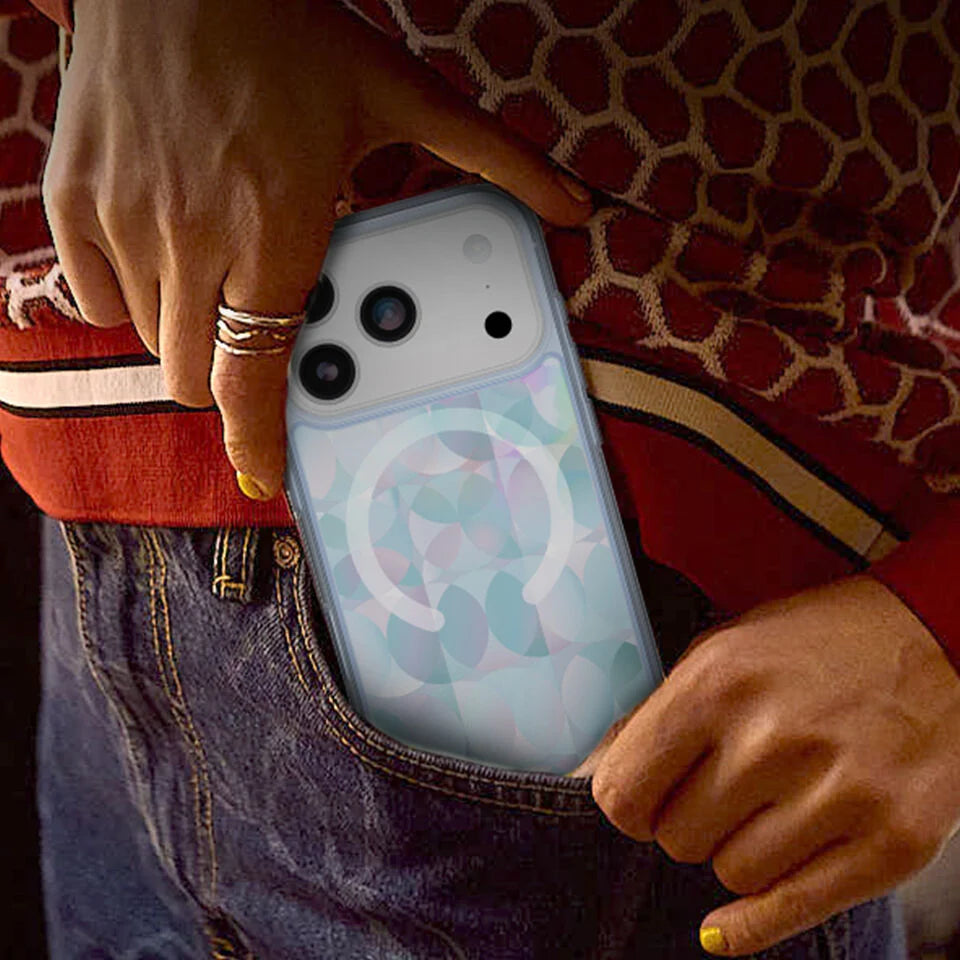 Person holding a phone with a colorful case against a patterned background