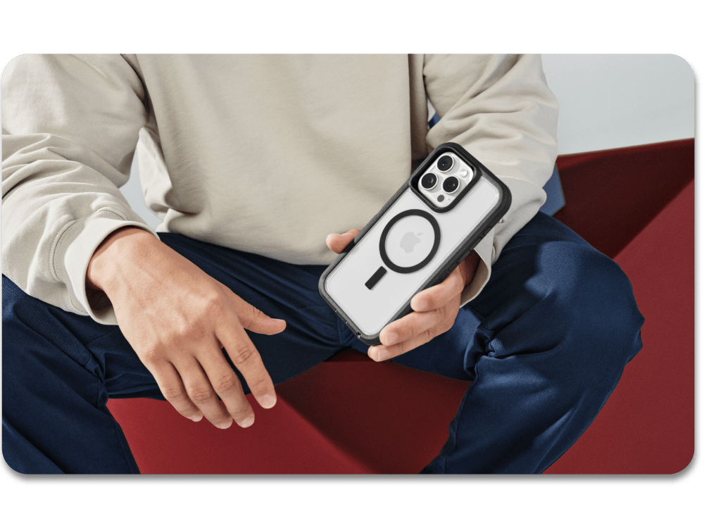 Person holding a phone with a distinctive case, sitting on a red chair.