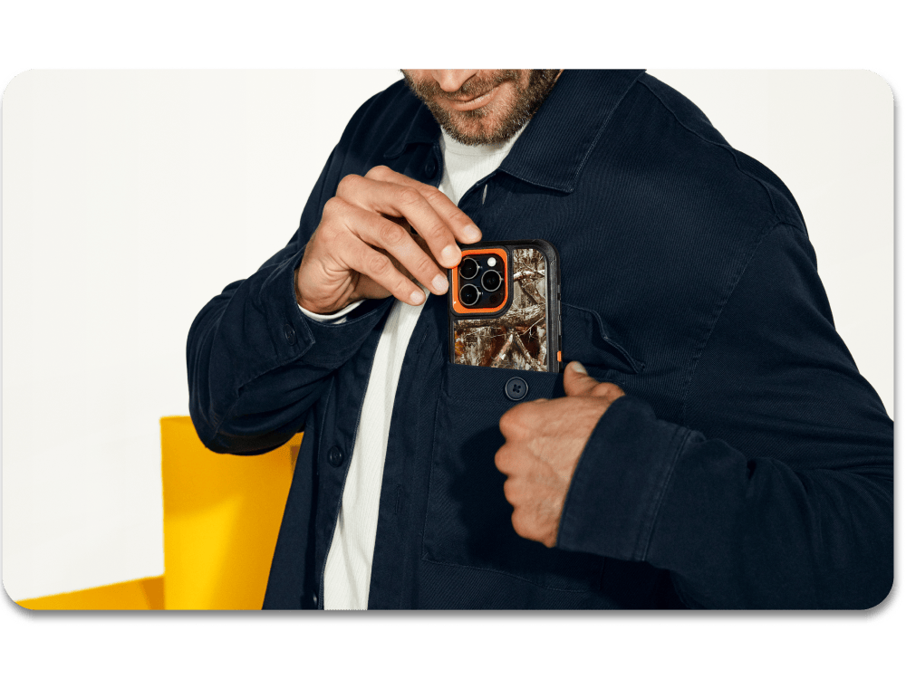 Person holding a phone case with camouflage design against a white background