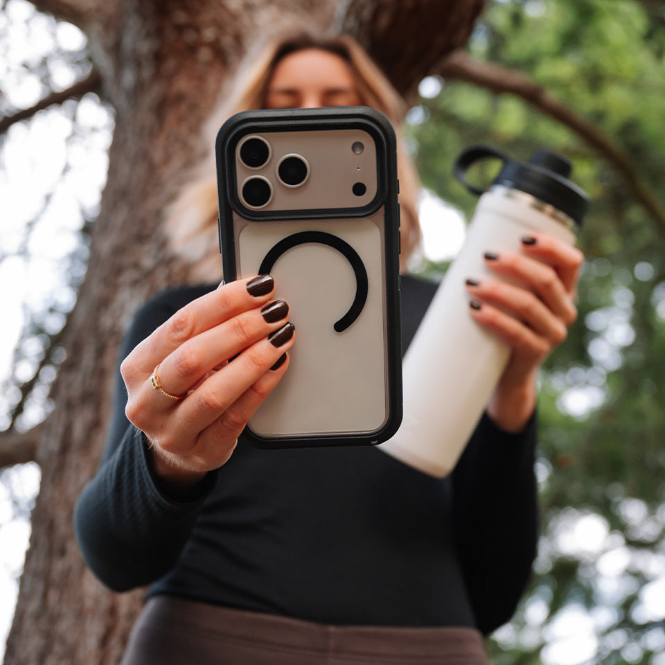 Person holding a phone case with a unique design outdoors
