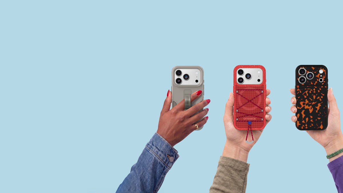 hands holding up different new iPhone phone cases from otterbox on a blue background
