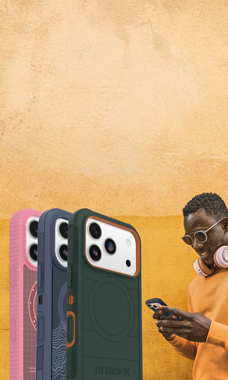 Four phone cases displayed in front of a person using a phone on a yellow background