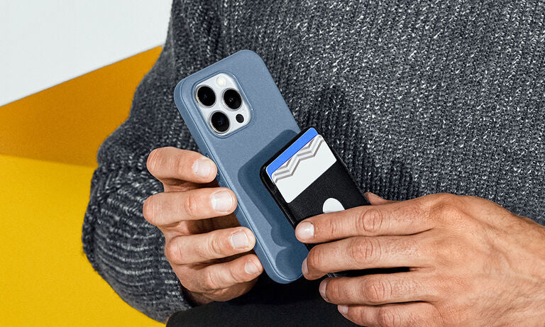 Person holding a phone with a blue case featuring card slots against a gray and yellow background