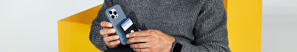 Person holding a smartphone with a protective case against a yellow background