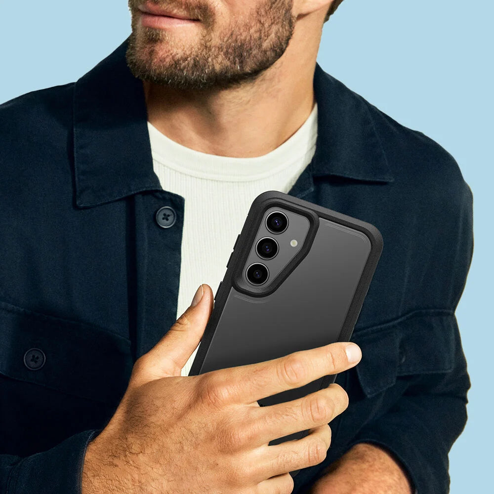 Man holding a smartphone with a black case against a blue background
