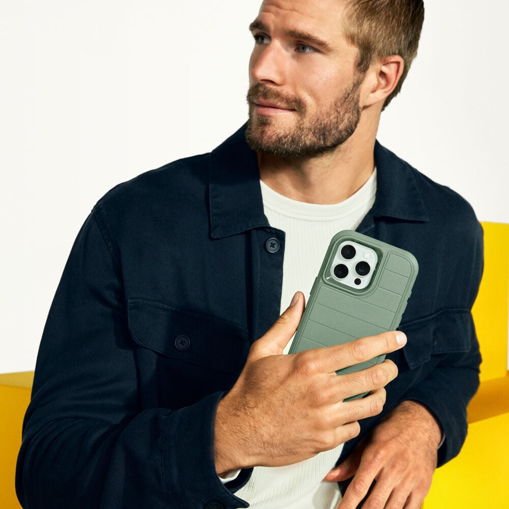 Man holding a green phone case against a white background