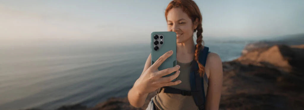 Woman taking a selfie on a beach with a phone