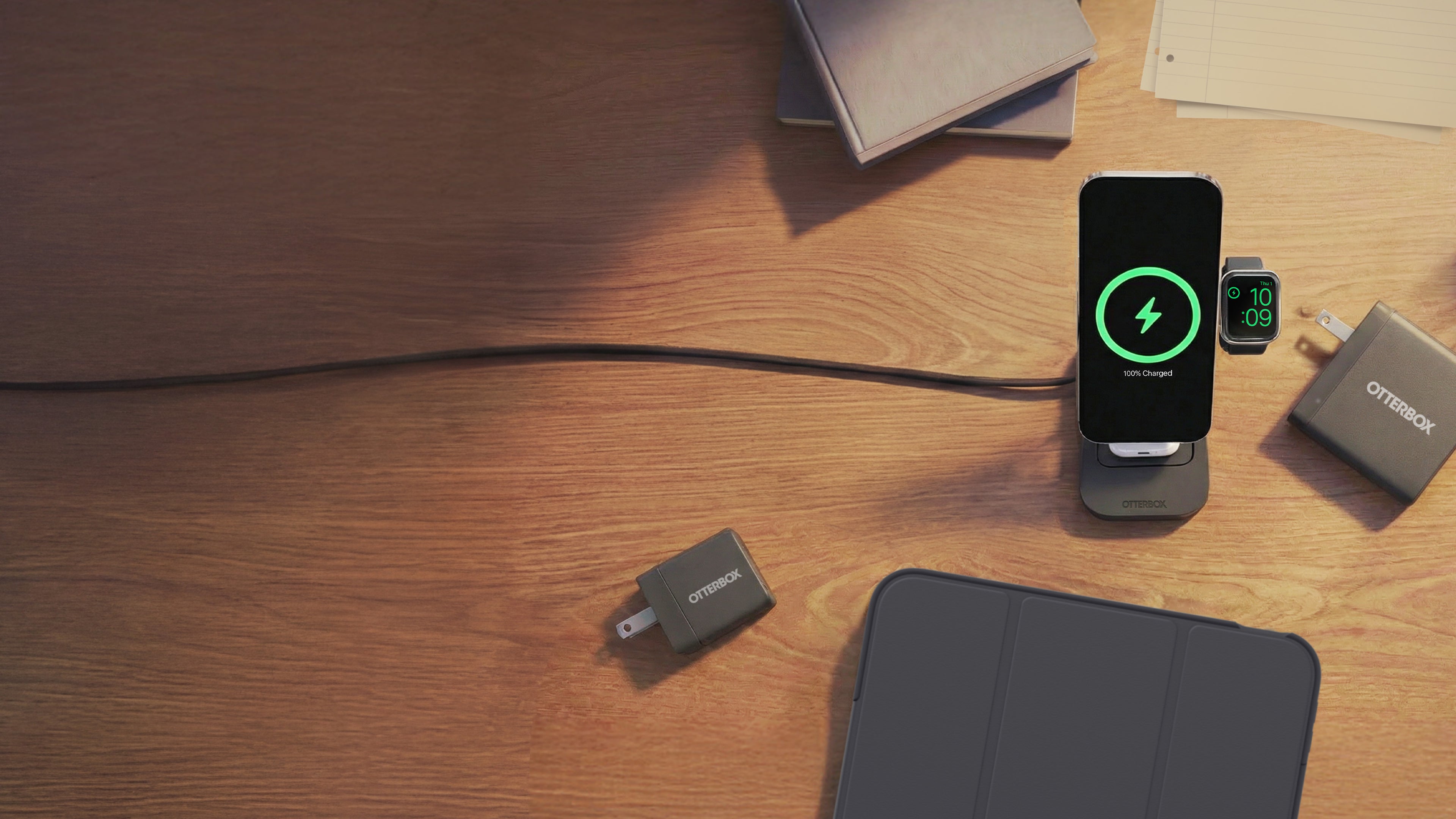 Smartphone charging on a stand with a green battery icon on a wooden surface.