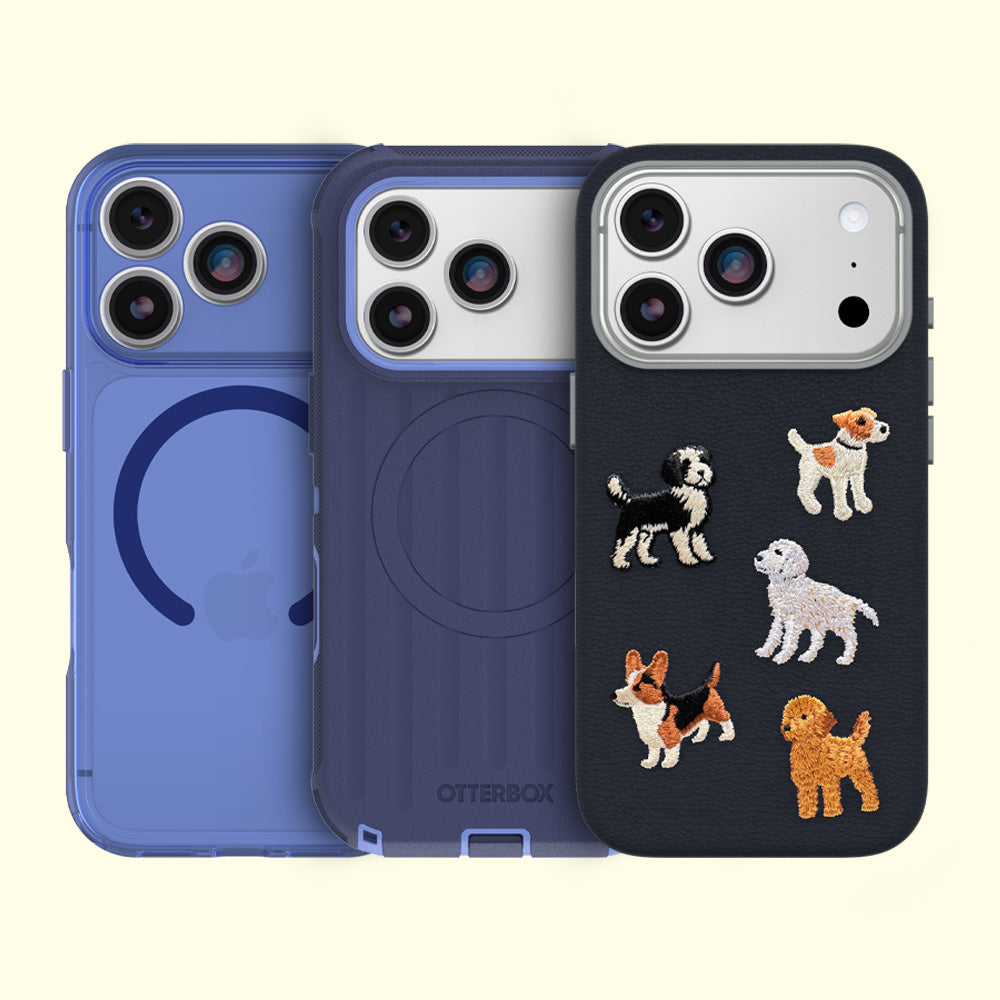 Three OtterBox phone cases shown on phone back mockups against a pale cream background. The left case is translucent blue, the middle is dark blue, and the right is black with embroidered dog illustrations.