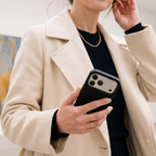 Person holding a smartphone in an OtterBox Symmetry Series Cactus Leather case, showcasing a premium leather-like finish in an everyday setting.
