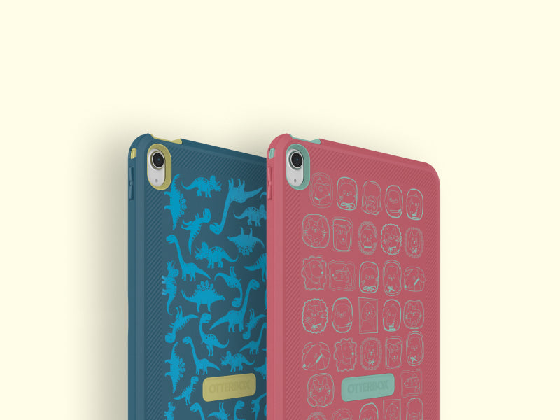 Two phone cases, one blue with dinosaur pattern and one pink with geometric pattern, on a light beige background.