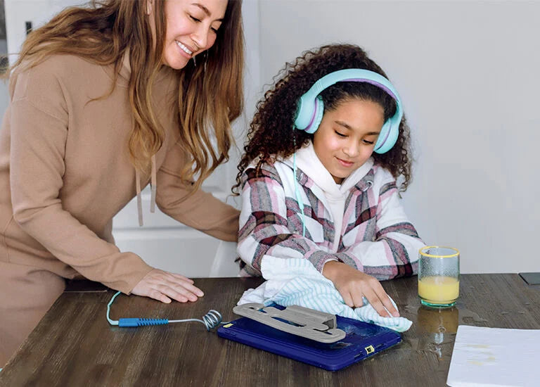 Woman and child at a table with tools and cleaning supplies, child wearing headphones.