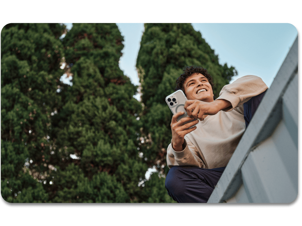 Person using a smartphone outdoors with trees in the background