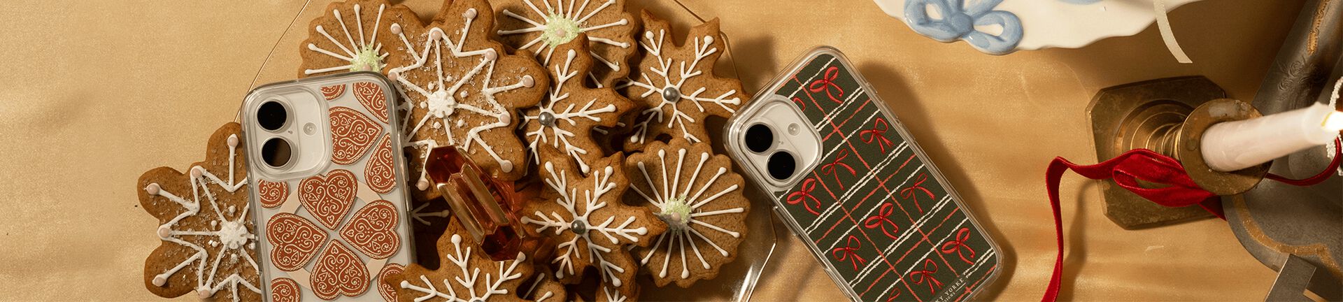 Otterbox iPhone 17 phone cases surrounded by holiday cookies and decorations